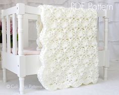 a white crocheted blanket sitting on top of a wooden chair next to a bed