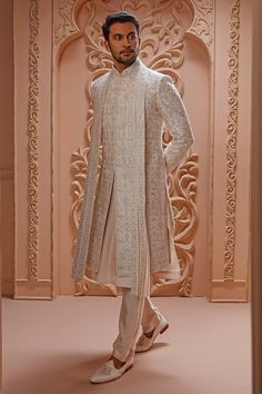 Cream sherwani with floral aari embroidery and mandarin collar. Paired with churidar, kurta and embroidered border dupatta.
Component: 4
Pattern: Embroidered
Type Of Work: Aari
Neckline: Mandarin
Sleeve Type: Full Sleeves
Fabric: Sherwani: Raw Silk, Kurta and Churidar: Crepe Silk, Dupatta: Georgette
Color: Cream
Other Details: 
Aari embroidery
Floral motifs
Embroidered border dupatta
Occasion: Wedding,Groom - Aza Fashions Cream Sherwani, Raw Silk Kurta, Wedding Kurta For Men, Aari Embroidery, Silk Kurta, Floral Set, Embroidered Border, Embroidery Floral, Silk Dupatta