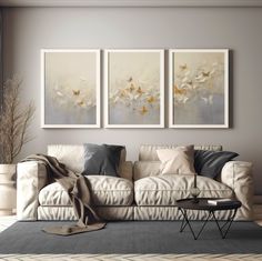 a living room with three paintings on the wall