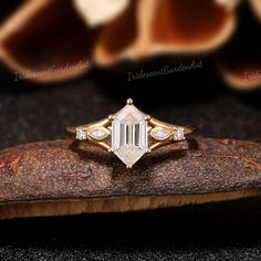 a diamond ring sitting on top of a piece of wood