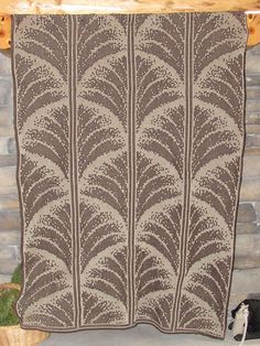 a brown and white knitted blanket sitting on top of a fireplace mantle next to a potted plant