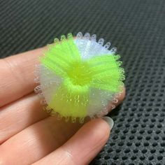 a hand holding a small green and white object