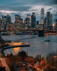 the city skyline is lit up at night as seen from across the river in new york