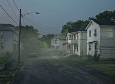 an empty street at night with houses on both sides