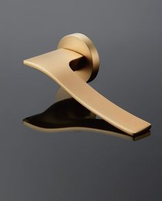 a gold phone holder with a black base and mirror on the top, in front of a gray background