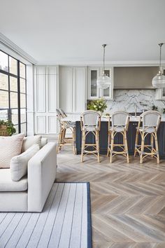 a living room filled with furniture next to a kitchen and dining room table in front of a window