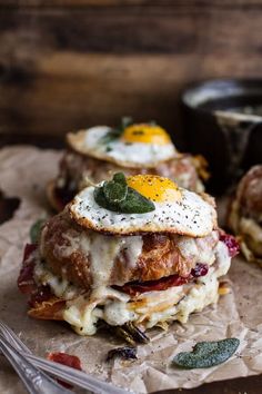 an egg and cheese sandwich on top of some paper with silverware next to it