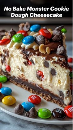 a slice of no bake monster cookie dough cheesecake on a plate with m & m candies