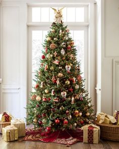 a decorated christmas tree in front of a window