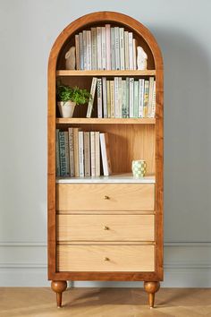 a wooden bookcase with books on top of it and two drawers in front of it