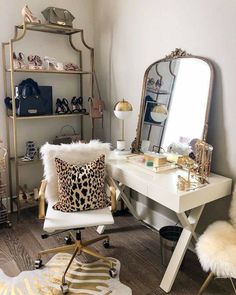 a white desk with a leopard print pillow on it and a gold framed mirror in the corner