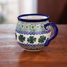 a blue and white coffee cup sitting on top of a wooden table