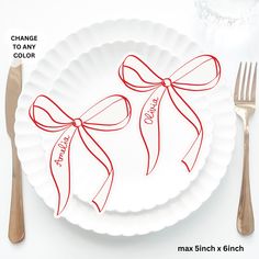 a white plate topped with a red ribbon and bow next to a fork and knife