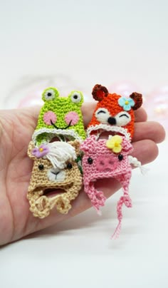 three small crocheted animals are held in someone's hand