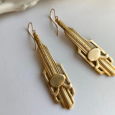 "1920s style long gold earrings, classic art deco dangles, Downton Abbey lover gift, gold bridesmaid earrings, elegant earrings DESIGN DETAILS These long (50mm - about 2\"), lightweight art deco detailed paddle pendants are a lovely matte scrubbed brass. Stamped with both classic straight lines and geometric curves reminiscent of the deco era, and the Chrysler building itself. Brushed pendants are stamped brass, lightweight and easy to wear. These are great everyday earrings, but even better for 1920s Earrings, Gold Art Deco Earrings, Titanic Jewelry, Bridesmaid Earrings Gold, Gold Bridesmaids, Long Gold Earrings, Earrings Classic, Deco Earrings, Chrysler Building