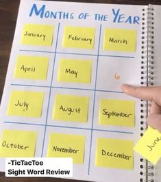 a hand pointing at a calendar with yellow sticky notes on it and the words months of the year