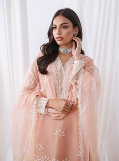 Defining our mesmerizing peach ensemble, which carries you to another dimension of ethereal beauty. Your look effortlessly refines everywhere you go, owing the exquisite cut work on the front of the apparel, which is meticulously crafted with threads, sequence jaal and pattern to add a touch of glamour and refinement. The coordinated pants also feature matching handwork, and the net dupatta is adorned with white embroidery that perfectly contrasts with your apparel. Embrace the romance of summer Feminine Chikankari Embroidery Sets For Wedding, Elegant Unstitched Peach Set, Elegant Peach Unstitched Set, Elegant Peach Sets For Eid, Feminine Sets For Wedding And Eid Celebrations, Feminine Sets For Wedding And Eid, Feminine Wedding Sets For Eid, Elegant Summer Sets With Pearl Embroidery, Elegant Peach Set With Chikankari Embroidery