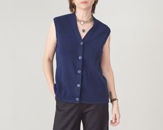 "Vintage Dark Blue Wool Sweater Vest size M | V-Neck Sweater Vest with Buttons Closure Composition: 100% wool Measurements while lying flat: Armpit to armpit: 45 cm | 17.7\" Length: 60 cm | 23.6\" Shoulder to shoulder: 38 cm | 15\" Condition: excellent.  This dark blue wool sweater vest is photographed on a size S model (chest: 88 cm|35\", waist: 68|26\" cm, hips: 88 cm|35\", height: 1,68 m|5.5ft) The tuxedo style, black wool pants in the pictures are made by us, they are 100% wool and you can order your custom size here: https://etsy.me/3TYqYYJ Our shop is dedicated to curated vintage and handmade clothing, fine fabrics only. Check out our vintage wool selection for more similar wool essentials: https://etsy.me/3PXiFti We offer discounts for multiple purchases: Buy any 2 items in shop and Blue V-neck Sweater Vest For Fall, Blue V-neck Sweater For Layering, Blue Cashmere V-neck Sweater, Blue V-neck Cashmere Sweater, Blue Wool Cardigan For Layering, Navy Wool Tops For Fall, Blue Cashmere Tops For Work, Fitted Cashmere V-neck Sweater Vest, Cashmere V-neck Sweater Vest For Layering