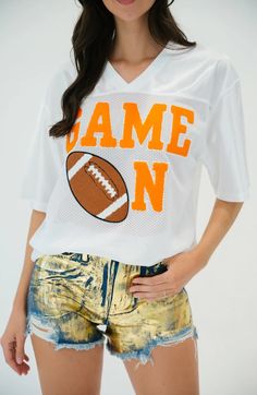 Rep your team in style with our GAME ON JERSEY WITH ORANGE VARSITY. This luxurious jersey showcases your passion for the game in a sophisticated way with green lettering embellished with a football patch. Perfect for gameday, this statement piece will make you the envy of the stadium. S/M M/L L/XL Length 27.5” 29” 30” Waist 40-42” 42-44” 46-48” Varsity Letter, Color Games, Sporty Girls, Custom Jerseys, A Football, Word Games, Game On, Style Profile, Team Spirit