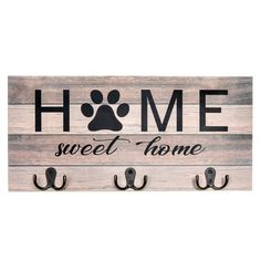 a wooden sign that says home sweet home with a paw print on the front and two hooks