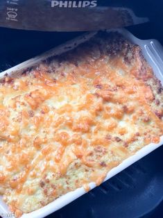 a casserole dish with cheese in it and a plastic container next to it