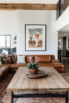 a living room filled with furniture and a wooden table in front of a painting on the wall