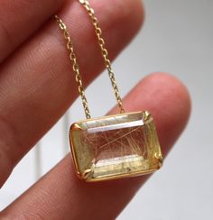 Unique rectangular rutiled quartz pendant set in gold-plated silver setting. The chain is gold-plated silver. Stone: Rutiled quartz  Chaine: 43cm Material: Gold-plated silver To see more necklaces, follow this link: https://www.etsy.com/shop/AtelierTiuh?section_id=27795402 Do not hesitate to contact me with any questions. Gold Faceted Rectangular Pendant Jewelry, Gold Faceted Necklace With Rectangular Pendant, Gold Necklace With Faceted Rectangular Pendant, Gold Faceted Rectangular Stone Jewelry, Gold Faceted Jewelry With Rectangular Stone, Gold Faceted Rectangular Necklace, Gold Rectangular Faceted Necklace, Rectangular Gold Necklace With Gemstone, All That Glitters