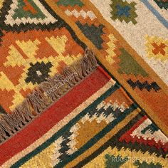 an old rug with many different colors and patterns on the ground, including red, yellow, green, blue, orange, and white