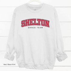 Shelton Dance Team Shirt If you’re the school spirit type, this Shelton High School Dance Team Shirt is for you! Get ready to show your SHS pride with this comfortable and stylish shirt, perfect for cheering on your favorite dance squad. Go Climbers!! Choose T-shirt, Crewneck Sweatshirt or Hoodie Sweatshirt. Super comfy unisex sizes. Our shirts, hoodies, and sweatshirts are crafted with comfort and quality in mind. Made from premium materials, they are soft, durable, and perfect for everyday wea School Spirit Stretch Tops For Cheerleading, Sporty Stretch Tops For School, White Stretch School Spirit Top, White Stretch Tops For School Spirit, Cotton Tops For College Events, Varsity Tops With Team Name For College Events, Sporty Tops With Team Name For College Events, Sporty Letter Print Tops For College Events, Sporty Tops With Letter Print For College Events