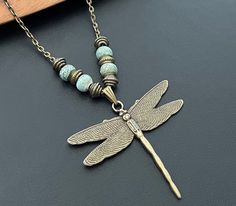 Beautiful handmade boho Dragonfly antique bronze gold necklace with ceramic turquoise beads. Available in 14 - 40 inch chain or brown leather cord  Please feel free to visit our other store for a large variety of beautiful boho earrings. www.etsy.com/shop/Indigoofcheshire Thank you for your interest Bronze Gold, Dragonfly Jewelry, Dragonfly Charm, Bronze Necklace, Turquoise Bead Necklaces, Bronze Pendant, Handmade Boho, Turquoise Beads, Boho Necklace