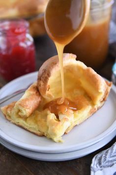 someone pouring caramel sauce on top of an egg omelet that is on a plate