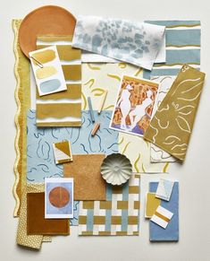 an assortment of art and craft supplies are arranged on a white surface with yellow accents