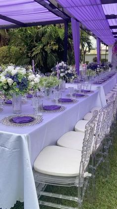 a long table is set with purple and white flowers