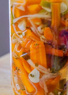 a jar filled with sliced carrots and onions