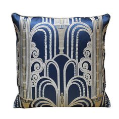 a blue and white pillow with an intricate design on the front, along with a gold border