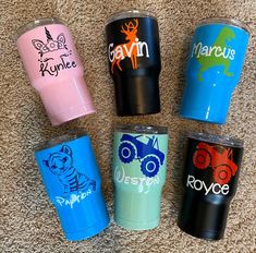 four different colored tumblers sitting on top of a carpet next to an orange rug