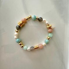 This fresh water pearl and mixed gemstone beaded bracelet features a  mix of 18K gold-filled beads with a fun mix of pastel shades of light greens and peach natural gemstone beads. It is the perfect bracelet to wear alone or add to your bracelet stack. It will make as a great gift to others and even yourself!  Materials: This bracelet features a mixed array of all natural healing gemstones with dainty freshy water pearls and is finished with 18K gold filled hardware.  Gemstones: Aquamarine, Lari Gold Beaded Bracelets With Pearl And Gemstone Beads, Gold Pearl Bracelets With Gemstone Beads, Multicolor Pearl Bracelet With Gemstone Beads, Pearl Beaded Bracelets With Natural Stones, Natural Stone Pearl Beaded Bracelets, House Gift Box, Candy Bracelet, Bracelets Ideas, Healing Gemstones