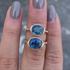 two rings with blue and white diamonds on each one, sitting next to each other