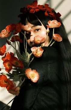 a woman with long black hair and flowers on her head