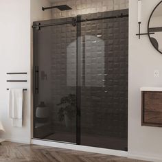 a bathroom with a glass shower door next to a sink and mirror on the wall