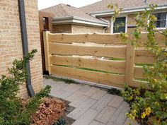 a wooden fence in front of a brick house