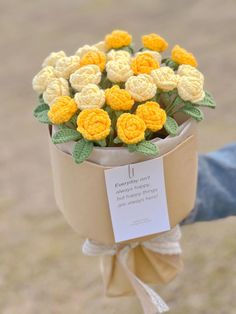 a bouquet of yellow and white flowers wrapped in brown paper