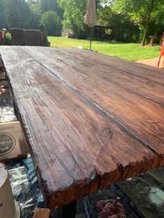 a wooden table sitting in the middle of a yard