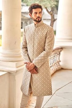 Beige sherwani featuring chikankari floral motif highlighted  with zardozi embroidery. Paired with churidar.
Component: 2
Pattern: Embroidered
Type Of Work: Zardozi
Neckline: Mandarin Collar
Sleeve Type: Straight Full
Fabric: Chikankari, Silk
Color: Beige
Other Details: 
Intricate floral motifs
Zardozi highlights
Front and side slit sherwani
Note: The green bandhgala set worn by the model on the right is not for sale
Occasion: Groom - Aza Fashions Chikankari Sherwani For Men, Kameez Ideas, Indian Wedding Clothes For Men, Sherwani For Men Wedding, Wedding Kurta For Men, Marathi Wedding, Haldi Outfits, Groom Dress Men, Wedding Outfits For Groom