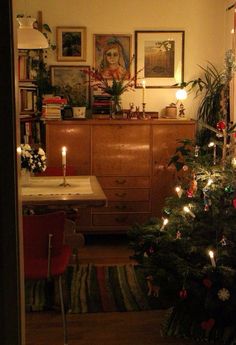 a living room with a christmas tree in the corner and other decorations on the wall