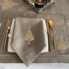 a place setting with napkins, silverware and candles