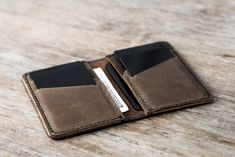 two wallets sitting on top of a wooden table