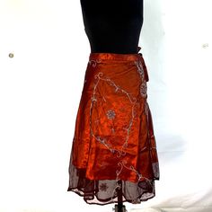 Our double layer Midi Lotus Flower Aari Skirt is a stunning decorative wrap around skirt that hugs your waist & hips, letting the elegant embroidered cloth do the rest!   The vintage sheer outer material is elaborately decorated & finished in traditional Aari style.  Handmade from fine quality vintage Silk saris ensuring every dress is unique just like you!  In India, these sari are very popular wear at weddings and parties.  The under-layer is a vibrant satin material that shimmers as you move. Silk Festive Evening Skirt, Bollywood Style Embroidered Long Skirt, Bollywood Style Long Embroidered Skirt, Bollywood Style Silk Party Skirt, Bollywood Style Art Silk Party Skirt, Bollywood Art Silk Party Skirt, Bohemian Floral Embroidered Skirt For Party, Silk Skirt With Traditional Drape For Party, Fitted Art Silk Skirt For Festive Season