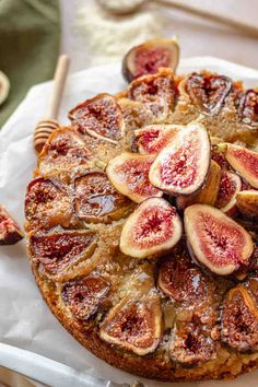 a cake topped with sliced figs on top of a white paper towel next to a fork