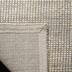 close up view of the corner of a cushion with an area rug on top of it